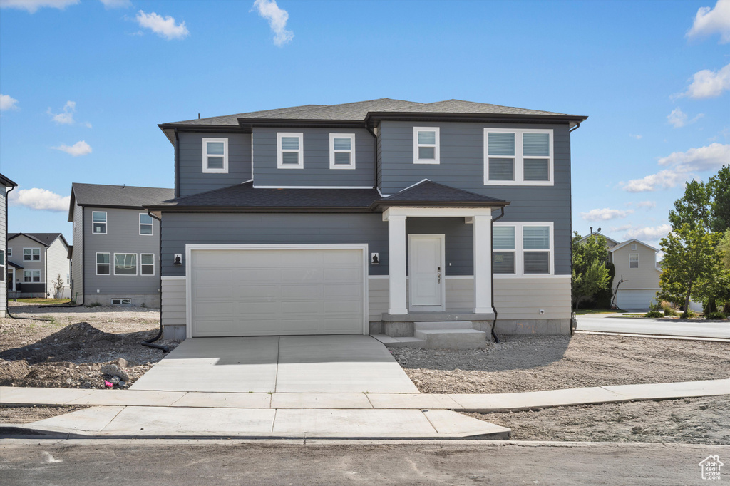 View of front facade with concrete driveway and an attached garage