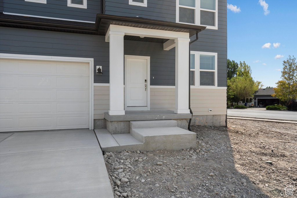 Property entrance with driveway and a garage