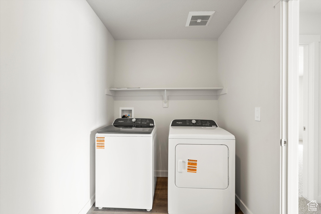 Laundry room featuring separate washer and dryer and wood finished floors