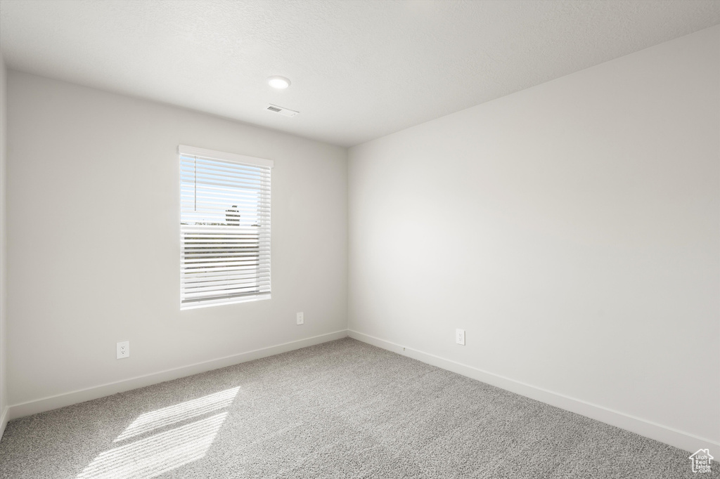 Empty room with carpet and baseboards