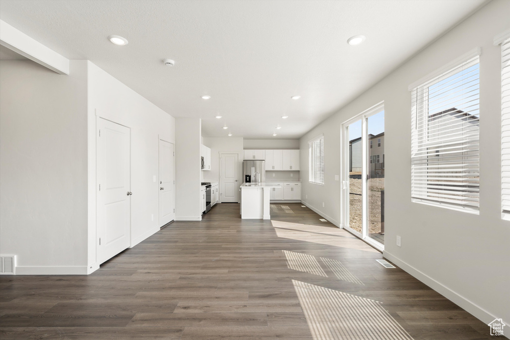 Unfurnished living room with recessed lighting and dark wood-type flooring