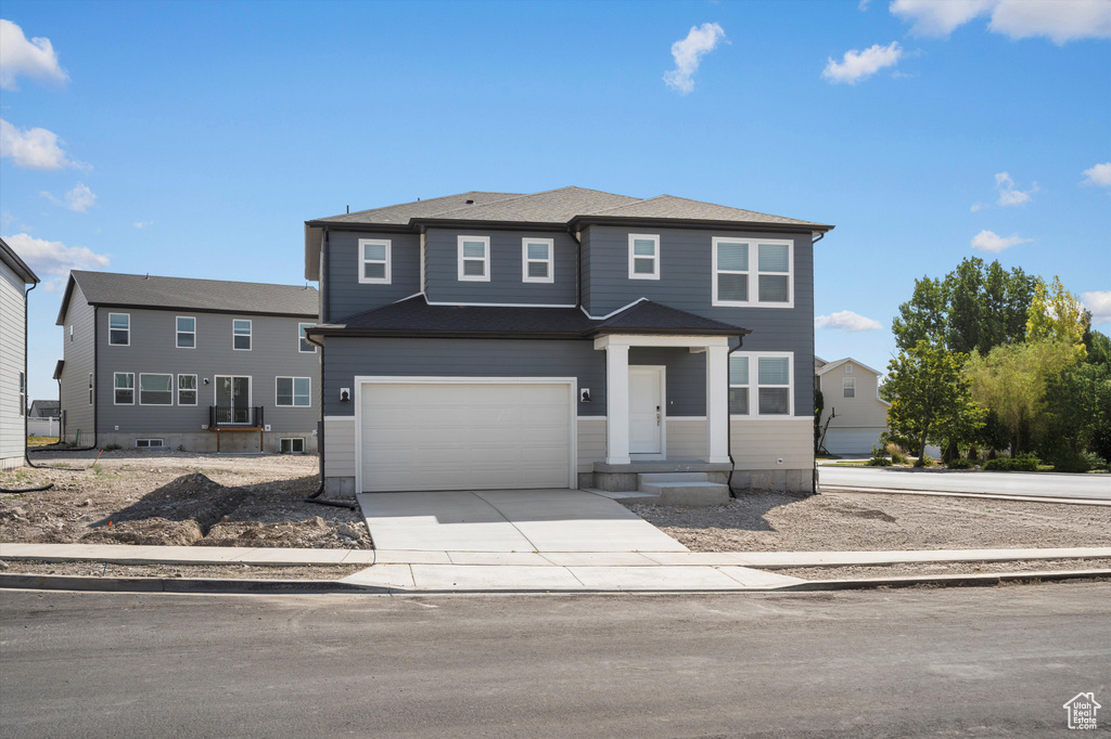 Traditional home featuring concrete driveway and an attached garage