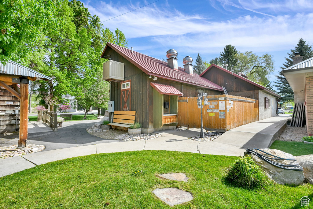 View of side of property with metal roof, a chimney, and a standing seam roof