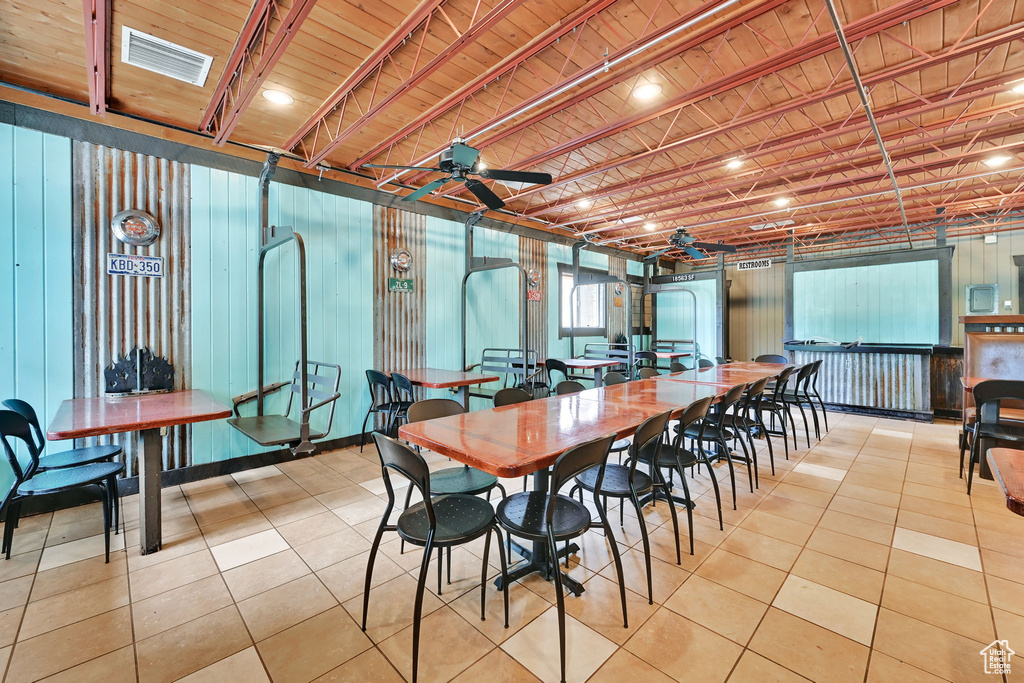 Tiled dining space featuring a ceiling fan