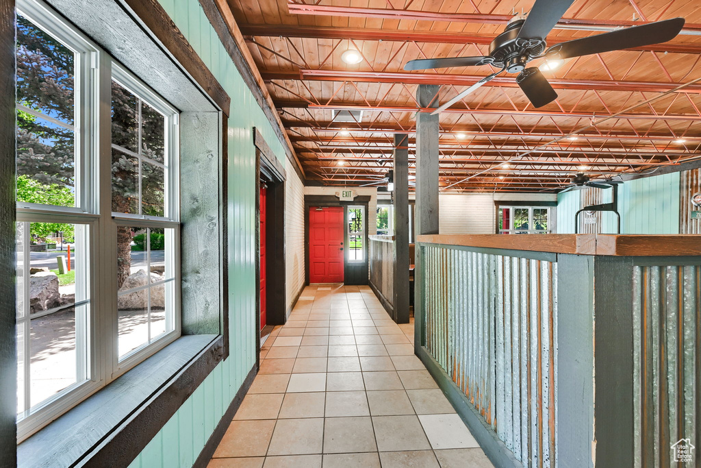 Hallway with light tile patterned floors, plenty of natural light, and wooden ceiling