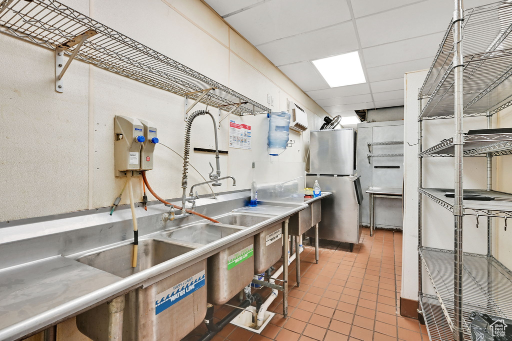 Kitchen with freestanding refrigerator, tile patterned flooring, and a drop ceiling