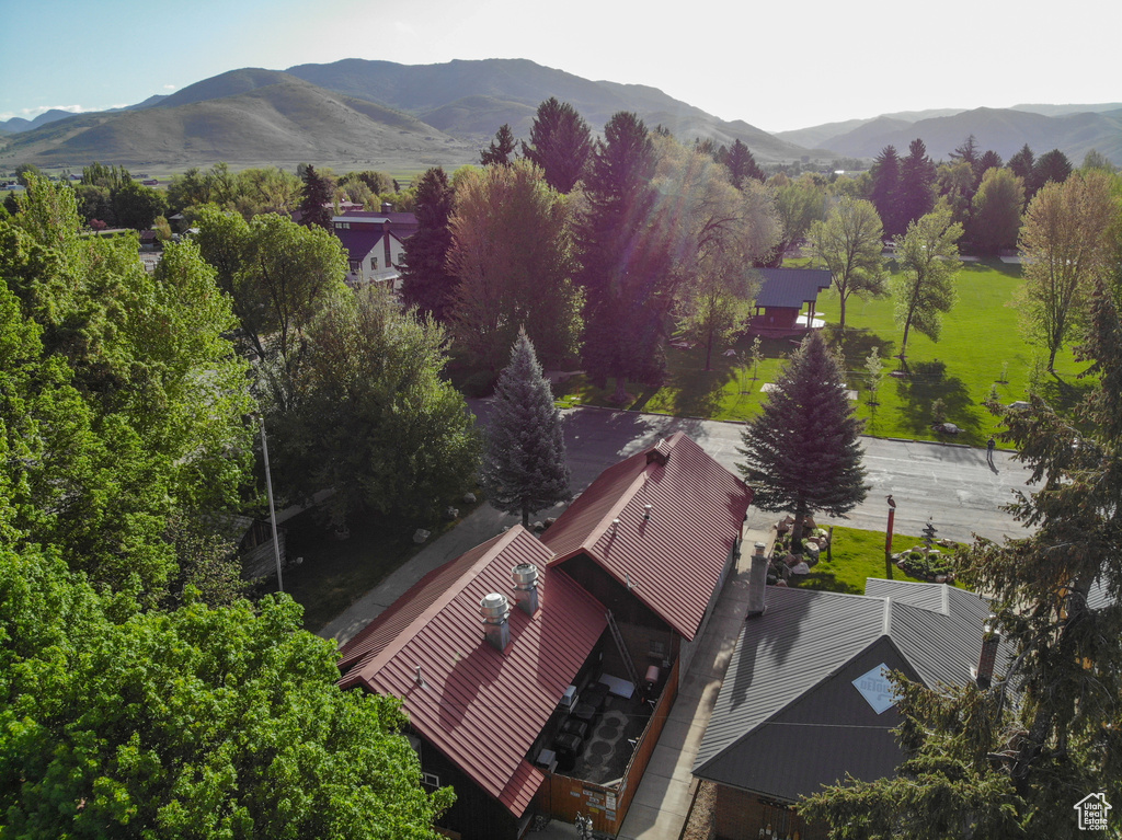 Aerial view of property and surrounding area featuring a mountain backdrop