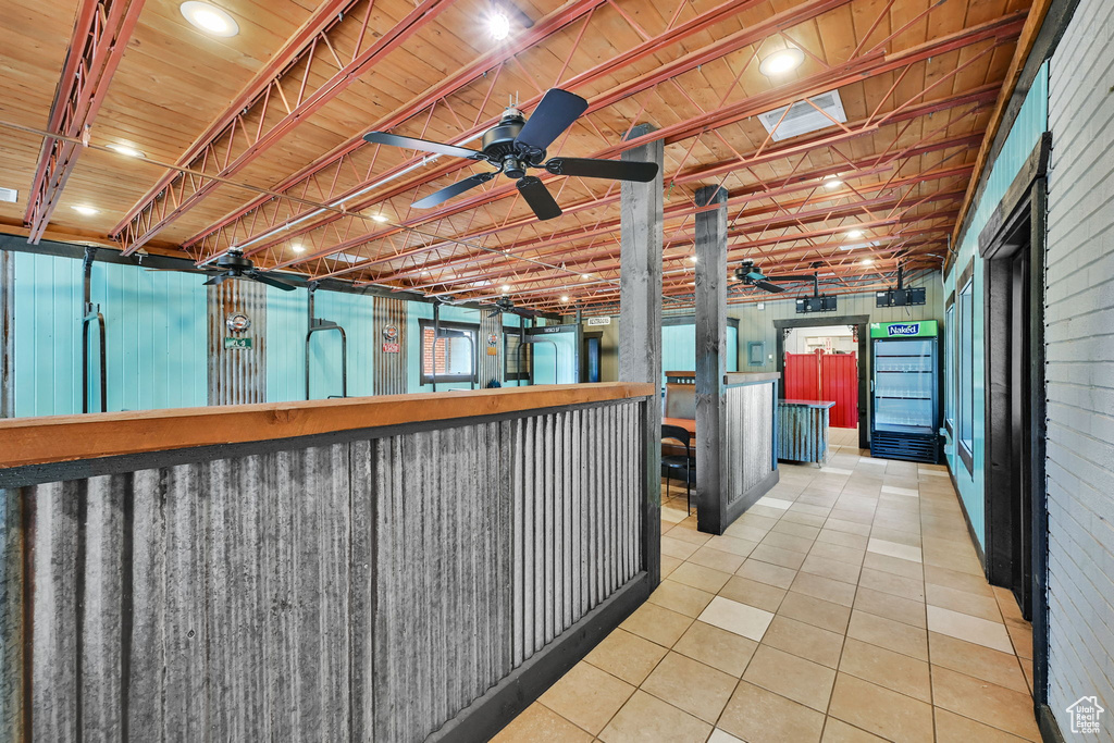 Below grade area with a ceiling fan and tile patterned floors
