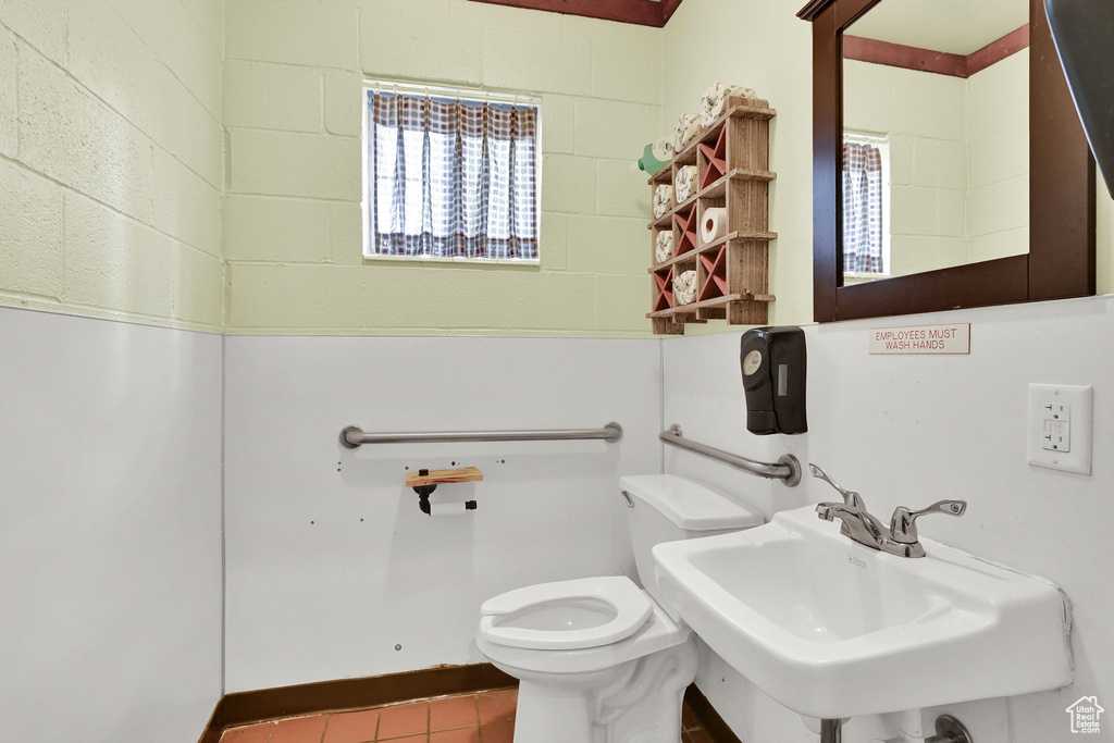 Bathroom featuring a sink, toilet, tile patterned floors, and healthy amount of natural light