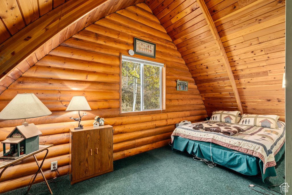 Bedroom with carpet floors, vaulted ceiling, rustic walls, and wood ceiling