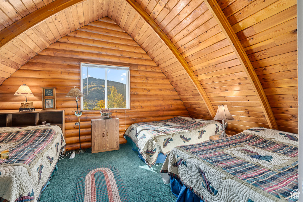 Bedroom with wooden ceiling, log walls, and carpet floors