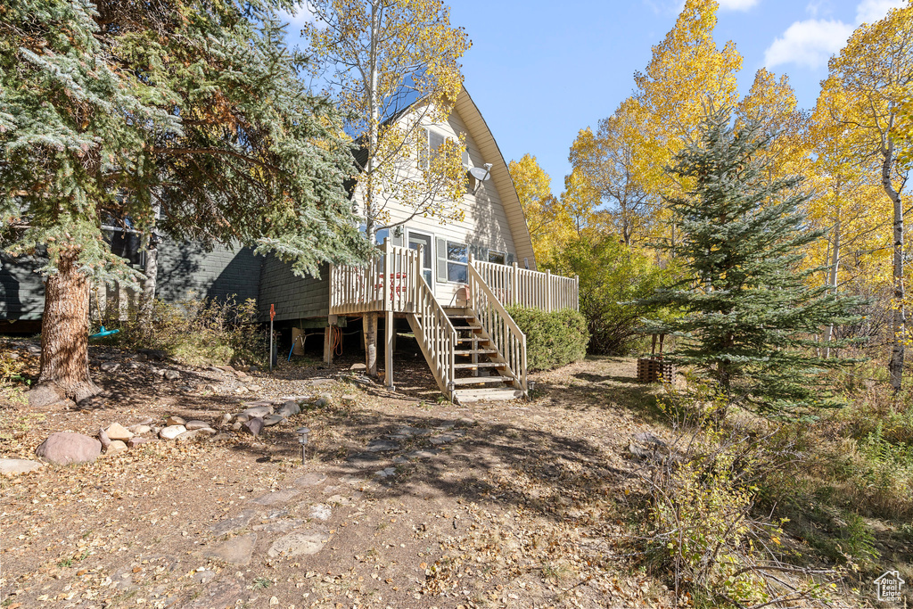 Back of house featuring stairs and a deck
