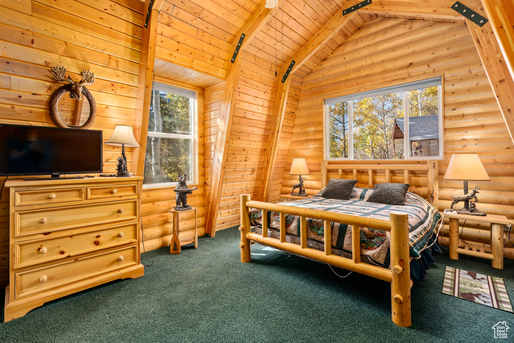 Bedroom featuring rustic walls, wood ceiling, and dark carpet
