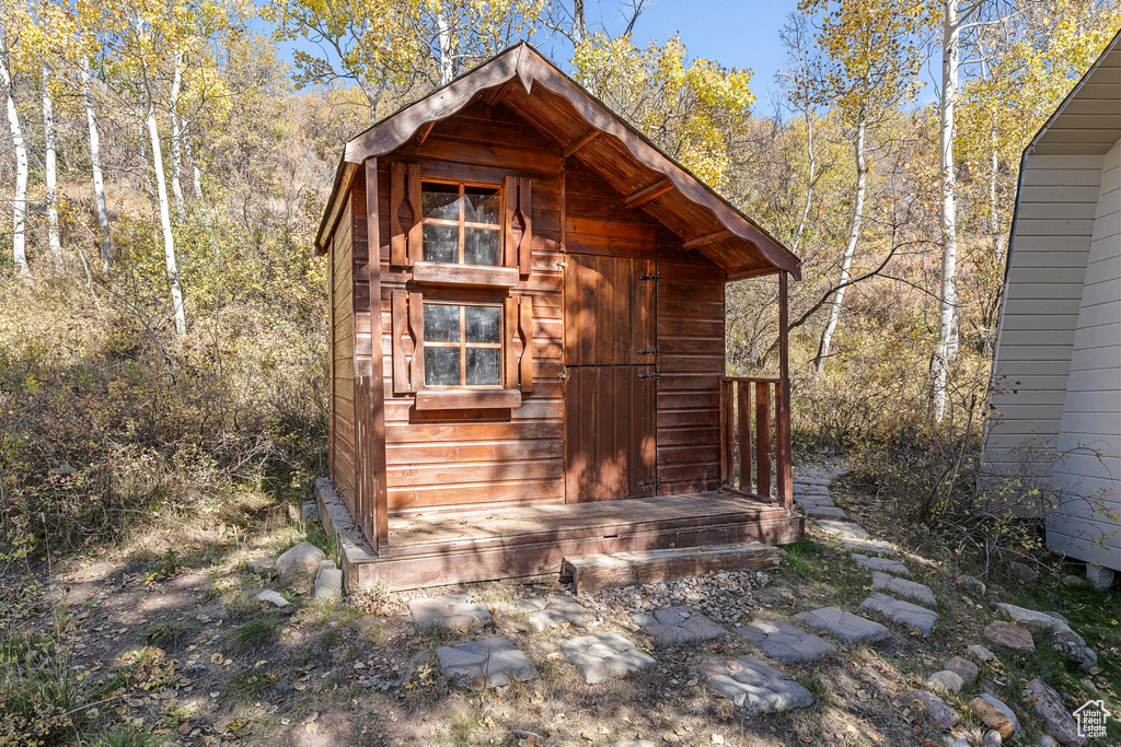 View of outdoor structure featuring an outbuilding and a wooded view