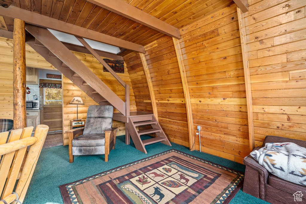 Bedroom with carpet, beamed ceiling, wooden ceiling, and wooden walls