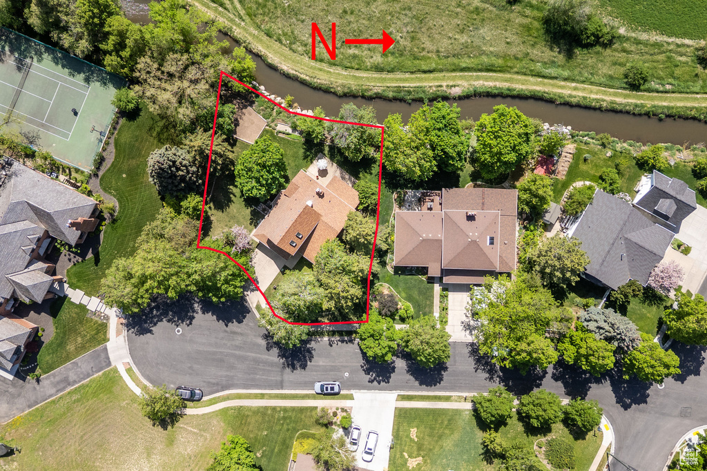 Aerial view of residential area with property parcel outlined and a large body of water