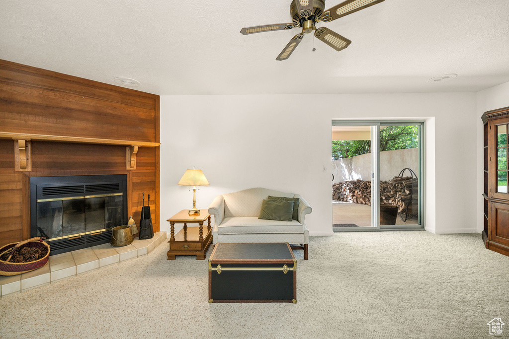 Living room with a ceiling fan, a fireplace, and baseboards