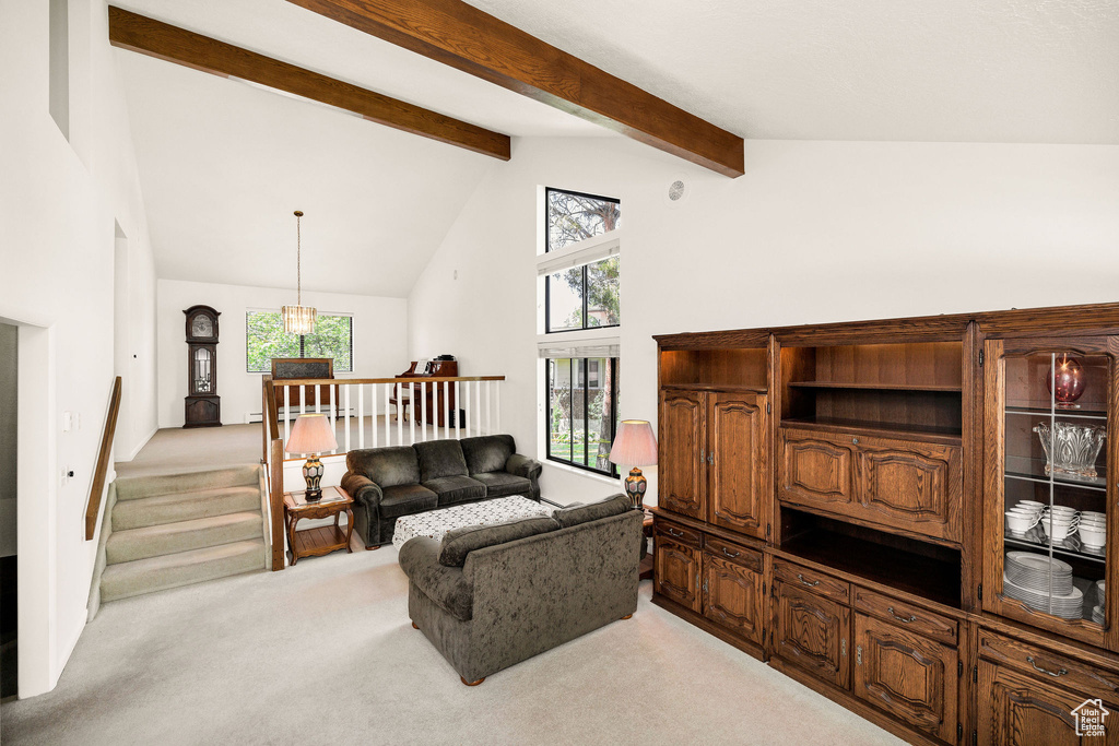 Living room featuring light colored carpet, high vaulted ceiling, beamed ceiling, and plenty of natural light