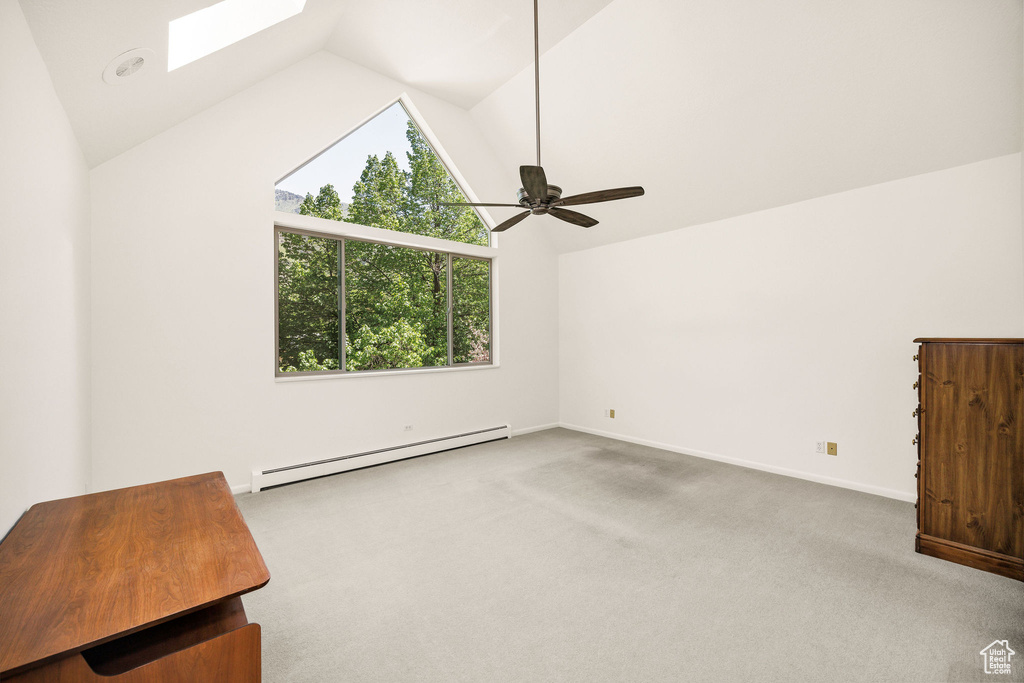 Additional living space with baseboard heating, lofted ceiling, a skylight, plenty of natural light, and carpet flooring