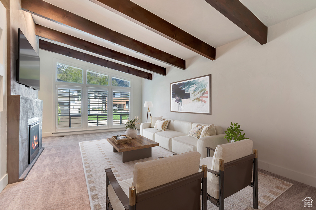 Living area with beam ceiling, baseboards, light colored carpet, and a fireplace