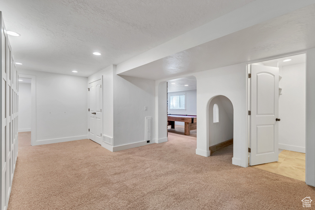 Basement featuring light carpet, a textured ceiling, baseboards, recessed lighting, and billiards