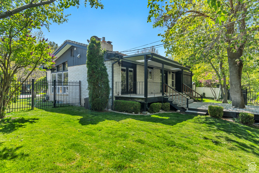 View of property exterior featuring a chimney, brick siding, and covered porch
