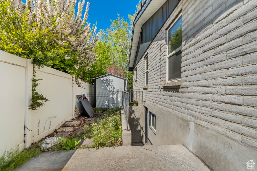 View of side of property featuring fence, a storage unit, and an outdoor structure