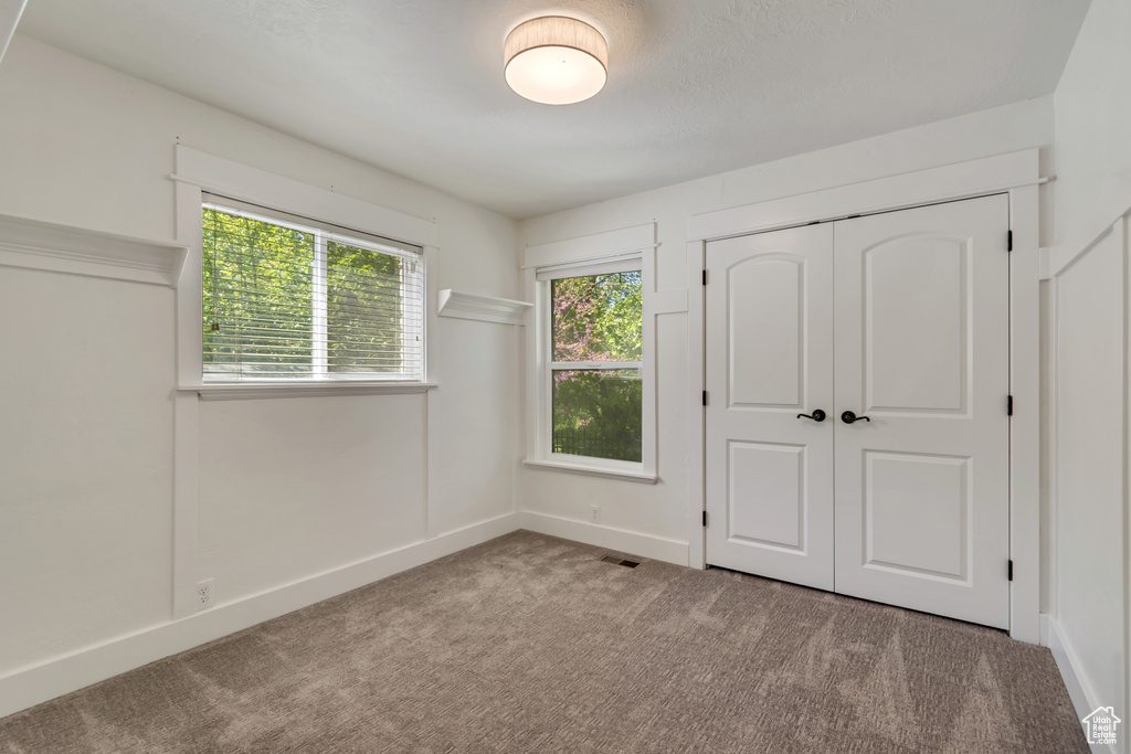 Unfurnished bedroom with carpet floors, a closet, and baseboards
