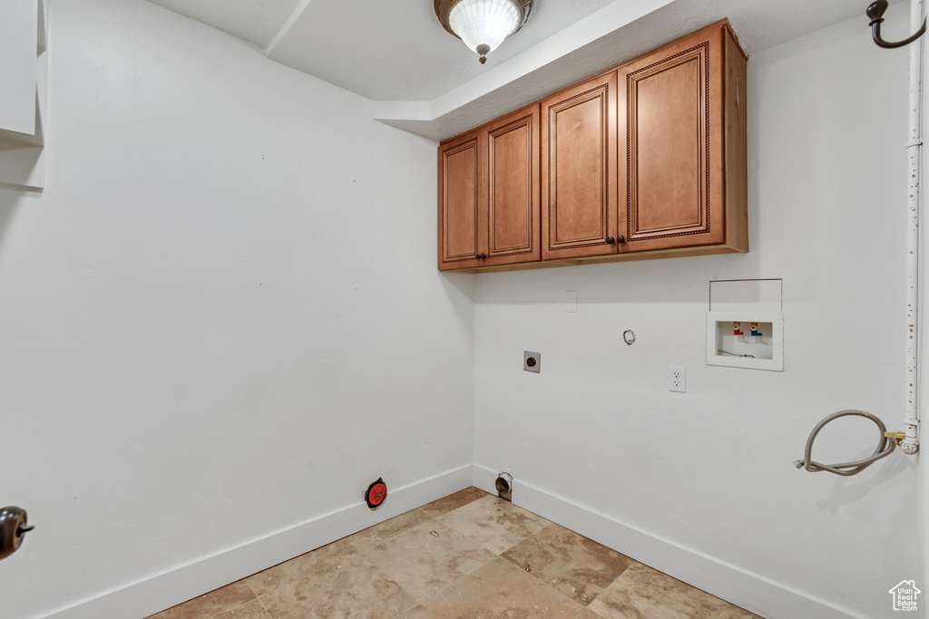 Laundry room with gas dryer hookup, baseboards, washer hookup, and cabinet space