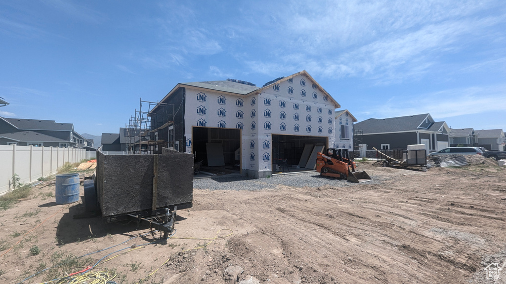 View of side of home featuring fence, a residential view, and stucco siding