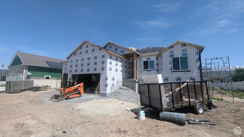 Rear view of house with fence and an attached garage