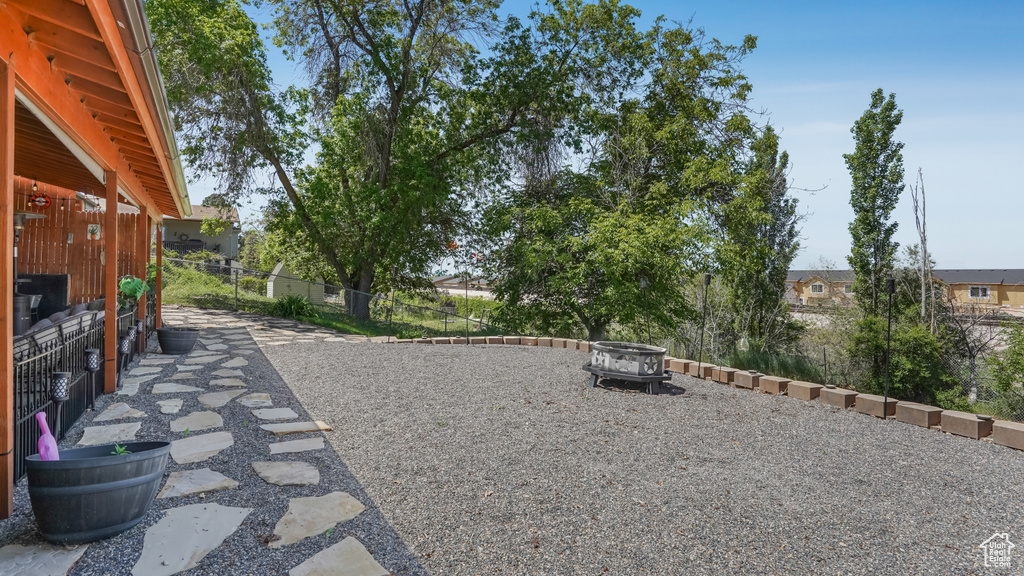 View of yard with an outdoor fire pit and fence