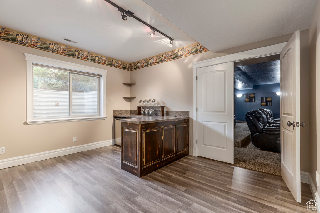 Bar area featuring rail lighting, wood finished floors, and baseboards