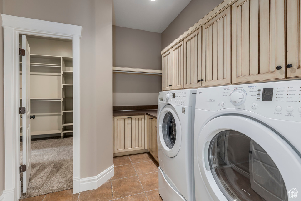 Washroom with separate washer and dryer, cabinet space, and light tile patterned flooring