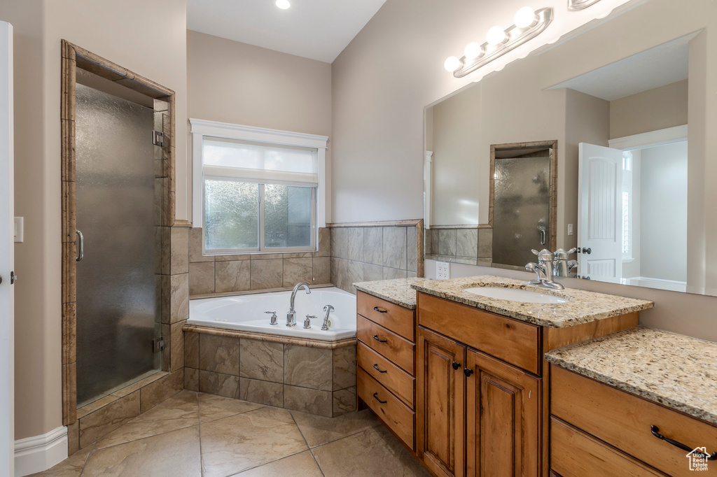 Full bath with a stall shower, a garden tub, and vanity