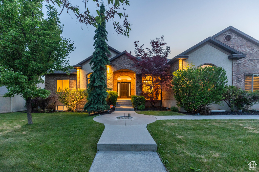 View of front of property with brick siding and a front yard