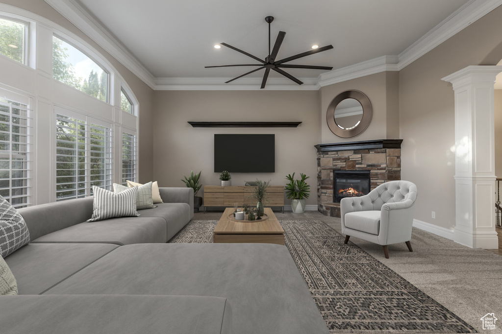 Carpeted living area featuring ornamental molding, a stone fireplace, decorative columns, recessed lighting, and baseboards