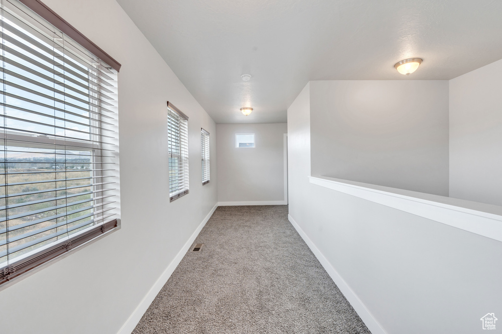 Hallway featuring carpet flooring and baseboards