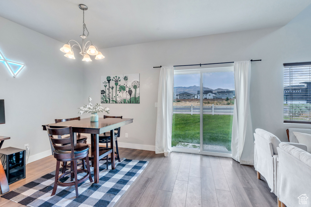 Dining space featuring a chandelier, wood finished floors, and baseboards