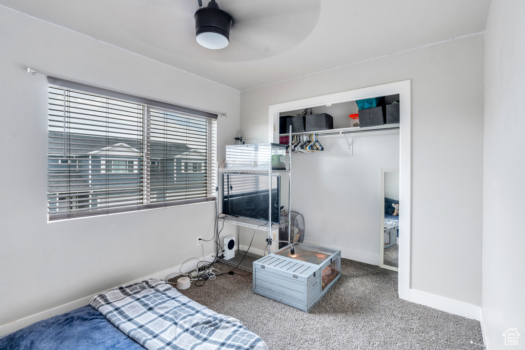 Carpeted bedroom featuring baseboards and a ceiling fan