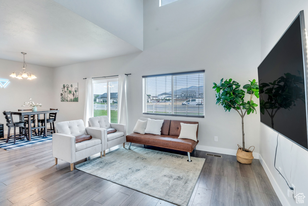 Living area with a chandelier, wood finished floors, and baseboards