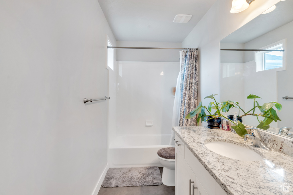 Full bathroom with vanity, toilet, shower / bath combo, and baseboards