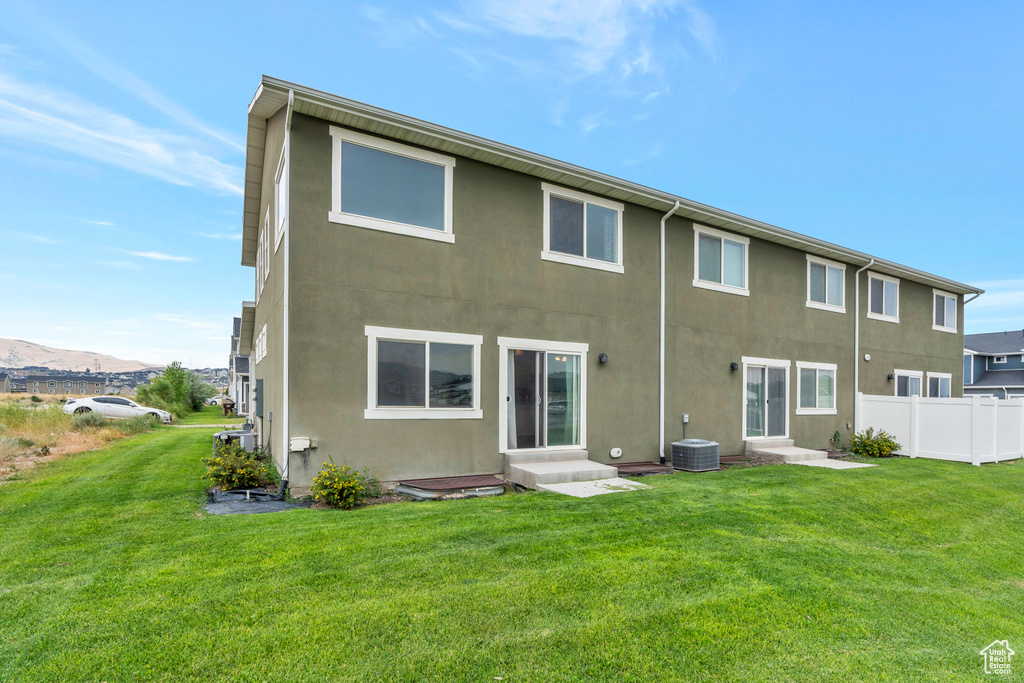 Rear view of house featuring entry steps, stucco siding, and cooling unit