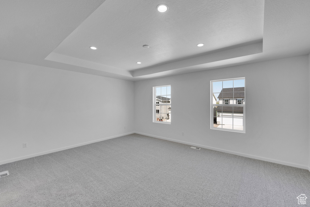 Unfurnished room featuring a raised ceiling, recessed lighting, baseboards, and carpet flooring