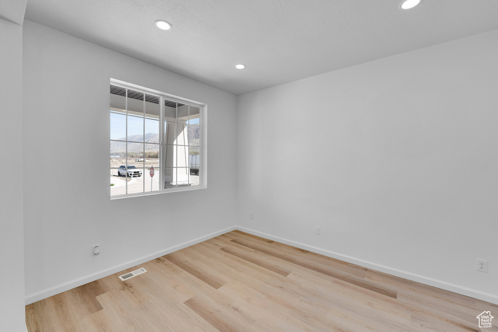 Empty room featuring recessed lighting, light wood-style flooring, and baseboards