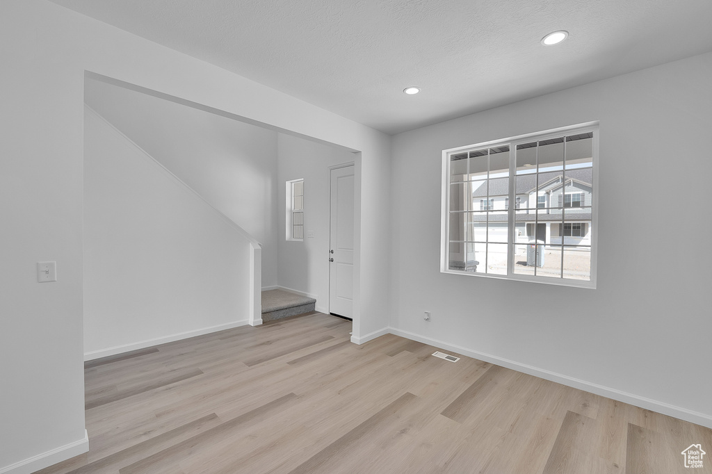 Unfurnished room with wood finished floors, baseboards, and recessed lighting