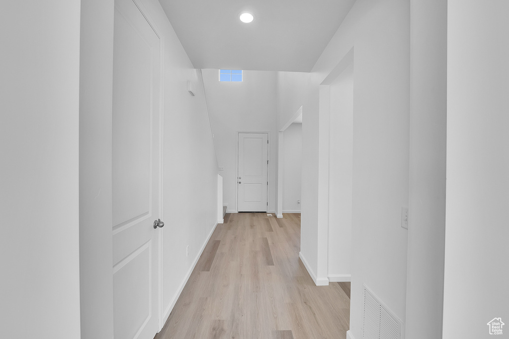 Hallway with light wood-type flooring, baseboards, and recessed lighting
