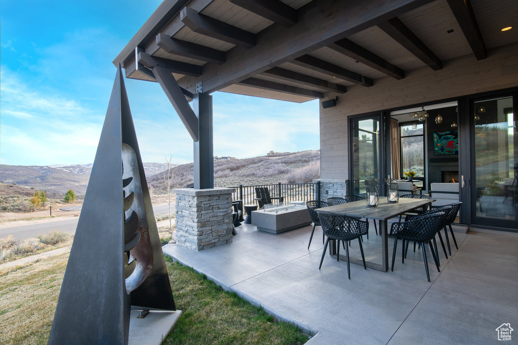 View of patio with a mountain view and outdoor dining area