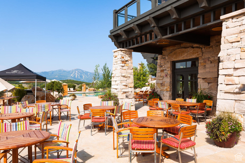 View of patio / terrace with a mountain view, a community pool, and outdoor dining space
