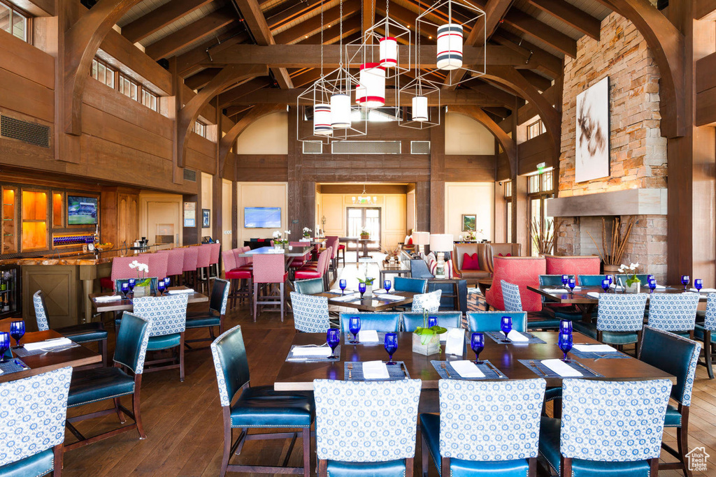 Dining room featuring high vaulted ceiling, hardwood / wood-style floors, and beam ceiling